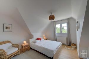 um quarto com uma cama, uma cadeira e uma janela em Le Bel Air / Maison de famille em Saint-Avertin