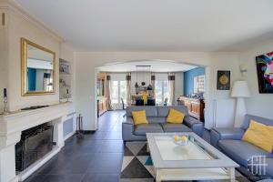 a living room with a blue couch and a fireplace at Le Bel Air / Maison de famille in Saint-Avertin