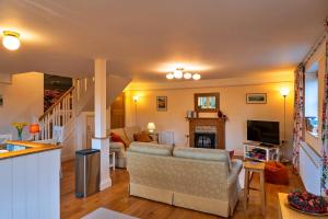 a living room with a couch and a tv at Finest Retreats - Lower School Cottages in Minehead