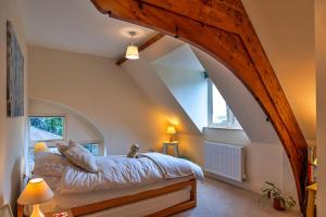 a bedroom with a large bed in an attic at Finest Retreats - Lower School Cottages in Minehead