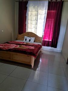 a bedroom with a bed with a pillow on it at Green Valley in Kigali
