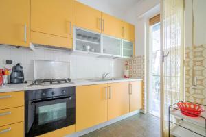 een keuken met gele kasten en een fornuis bij FAMILY House in Albissola Marina