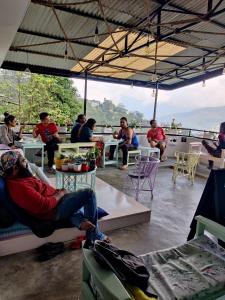 a group of people sitting at tables on a patio at Tag Along 2 0 Hostel Gangtok in Gangtok