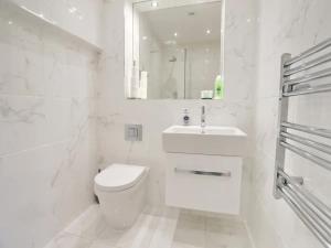 een witte badkamer met een toilet en een wastafel bij Pass the Keys Central 3 Bed Flat 8 Min Walk To City Centre in Manchester