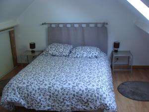 una camera da letto con un letto con un piumone bianco e nero di La grange a Gasny