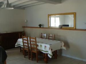 una sala da pranzo con tavolo, sedie e uno specchio di La grange a Gasny