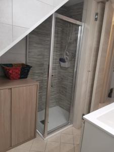 y baño con ducha y puerta de cristal. en KOMI HOUSE, en Sottomarina