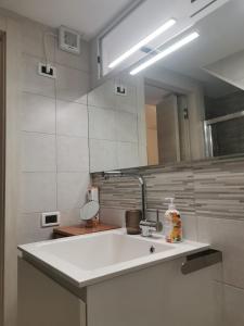 baño con lavabo y espejo grande en KOMI HOUSE, en Sottomarina