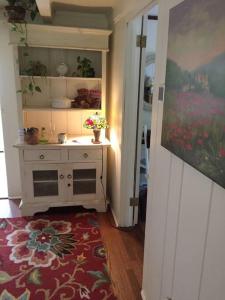 une cuisine avec une armoire blanche et un tapis rouge dans l'établissement Idyllic New England Cottage, à Wilton