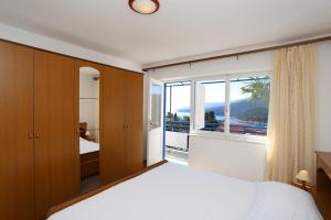 a bedroom with a bed and a large window at Apartments Marija 1000 in Rabac