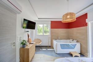 een badkamer met een bad en een tv. bij La Quintinha / détente et évasion in Fondettes