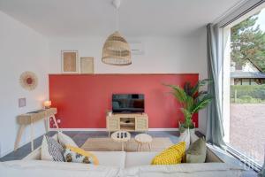 een woonkamer met een witte bank en een rode muur bij La Quintinha / détente et évasion in Fondettes