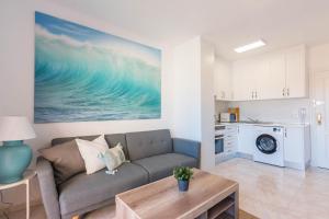 Una sala de estar con un sofá y una cocina. en URBANIZACIÓN COPACABANA - La Manga del Mar Menor KM2 - Vistas a Mediterráneo Dormitorio doble y sofá-cama, en La Manga del Mar Menor
