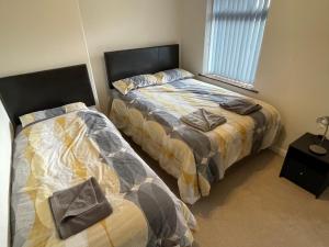 two beds sitting next to each other in a bedroom at Blackpool Entire holiday home - LEAVESLEY in Blackpool