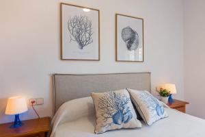 Un dormitorio con una cama con dos cuadros en la pared. en URBANIZACIÓN COPACABANA - La Manga del Mar Menor KM2 - Vistas a Mediterráneo Dormitorio doble y sofá-cama, en La Manga del Mar Menor 26 fotos más