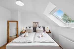 ein Schlafzimmer mit einem großen weißen Bett mit einem Fenster in der Unterkunft City Chalet - 73m2-Boxspringbett-neu renoviert-Küche-sehr ruhig in Bochum