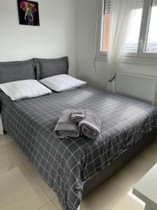 ein Bett mit Handtüchern darauf in einem Schlafzimmer in der Unterkunft Super 4 Pièces refait à neuf in Villeurbanne