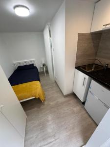 a small room with a bed and a sink at Single ensuite room in London
