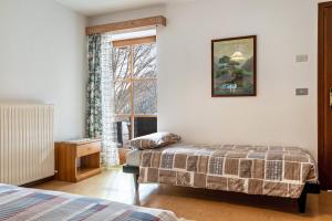 1 dormitorio con 2 camas y ventana en Agriturismo El Cirum Pelmo, en Livinallongo del Col di Lana