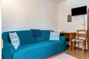 um sofá azul numa sala de estar com uma secretária em Agriturismo El Cirum Pelmo em Livinallongo del Col di Lana