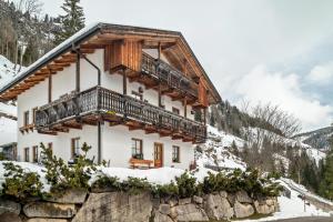 a house with a balcony on top of a mountain at Agriturismo El Cirum Pelmo in Livinallongo del Col di Lana