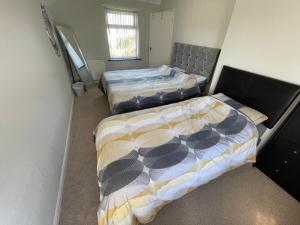 two beds in a small room with two bedsvisor at Blackpool Entire holiday home - LEAVESLEY in Blackpool