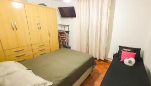a small bedroom with a bed and a dresser at Santos Gonzaga - Vista mar & localização perfeita in Santos