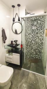 a bathroom with a shower and a toilet and a sink at Santos Gonzaga - Vista mar & localização perfeita in Santos