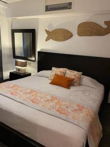 ein Schlafzimmer mit einem Bett mit Kissen und einem Spiegel in der Unterkunft Peaceful and lovely apartment! Front beach in Las Terrenas