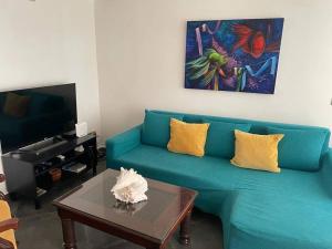 ein Wohnzimmer mit einem blauen Sofa und einem Couchtisch in der Unterkunft Peaceful and lovely apartment! Front beach in Las Terrenas
