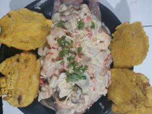 a plate of food with shrimp and coleslaw at Kitesurf Hostal Ocean House-Santa Verónica in Santa Veronica