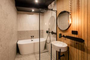 a bathroom with a sink and a toilet and a mirror at Slow Tatry Boutique Resort in Zakopane