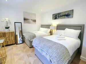 a bedroom with two beds and a mirror at Pass the Keys Super King Penthouse Minutes from Arndale Centre in Manchester