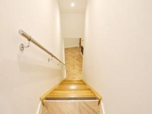 a stairway with a hand rail on a white wall at Pass the Keys Super King Penthouse Minutes from Arndale Centre in Manchester