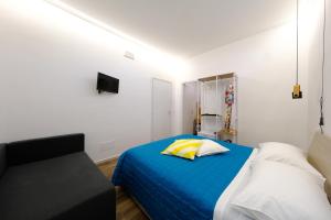a bedroom with a blue bed and a chair at Ama Casa Siracusa in Siracusa