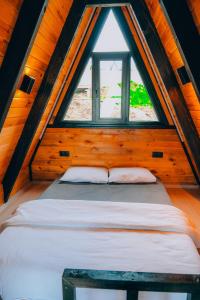 Cama en habitación de madera con ventana en Mouna Sapanca en Sapanca