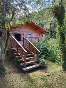 a wooden cabin with a staircase in front of it at Pousada Vale da Imbuia chalé para temporada in Urubici