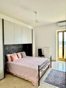 a bedroom with a large bed with pink pillows at Lenny House alloggio privato in Noci