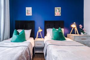 two beds in a room with blue walls at Fantastic Five Bedroom House By PureStay Short Lets & Serviced Accommodation South Yorkshire With Parking in Bentley