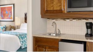 eine Küche mit einem Waschbecken und ein Zimmer mit einem Bett in der Unterkunft Hotel Aruba in Palm-Eagle Beach