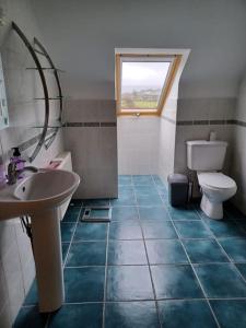 baño con lavabo y aseo y ventana en Marina View - Cahersiveen, en Cahersiveen