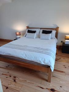 1 dormitorio con 1 cama con sábanas y almohadas blancas en Marina View - Cahersiveen, en Cahersiveen