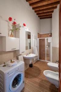 a bathroom with a washing machine and a sink at Casa d'Orcia in Pienza