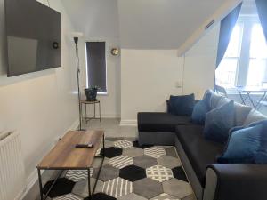 a living room with a couch and a table at 1 Bedroom Flat w/ 2 beds in Cardiff