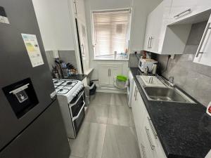 a small kitchen with a sink and a stove at Aldgate East Rooms R1 in London