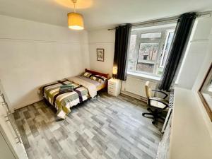 a bedroom with a bed and a chair in it at Aldgate East Rooms R1 in London