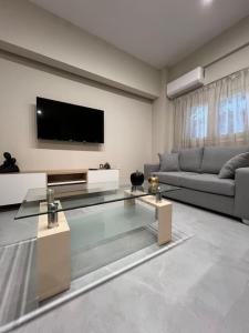 sala de estar con sofá y TV de pantalla plana en Melisa, en Pireo