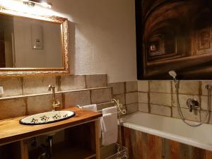 a bathroom with a sink and a bath tub at FeWo Am Klosterberg, Dormitorium in Ochsenhausen
