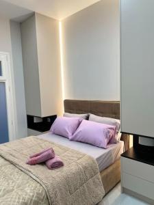 Un dormitorio con una cama con almohadas moradas. en Η Ιδανική Κατοικία για Χαλάρωση, en Pireo