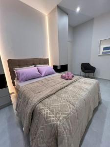 1 dormitorio con 1 cama grande con almohadas moradas en Melisa, en Pireo